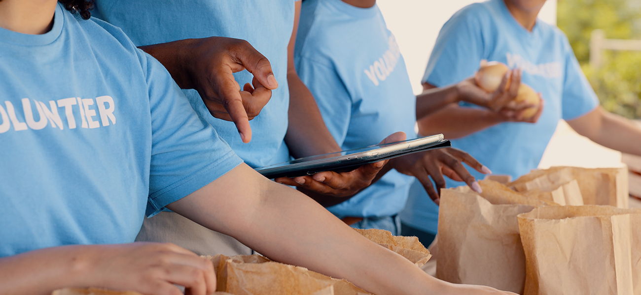 People volunteering, tablet and food donation in community service