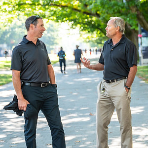 Two staff members in conversation on Main Mall